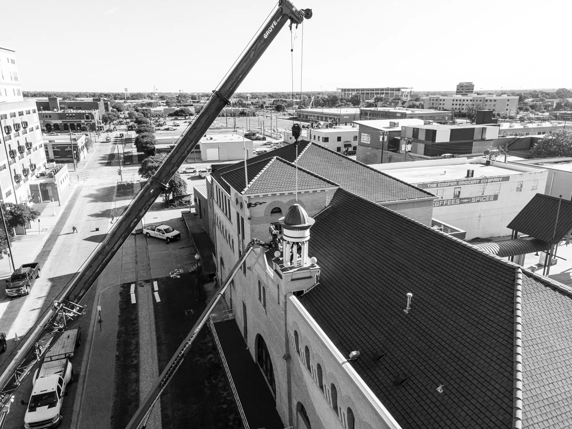 A crane placing an object on a building roof