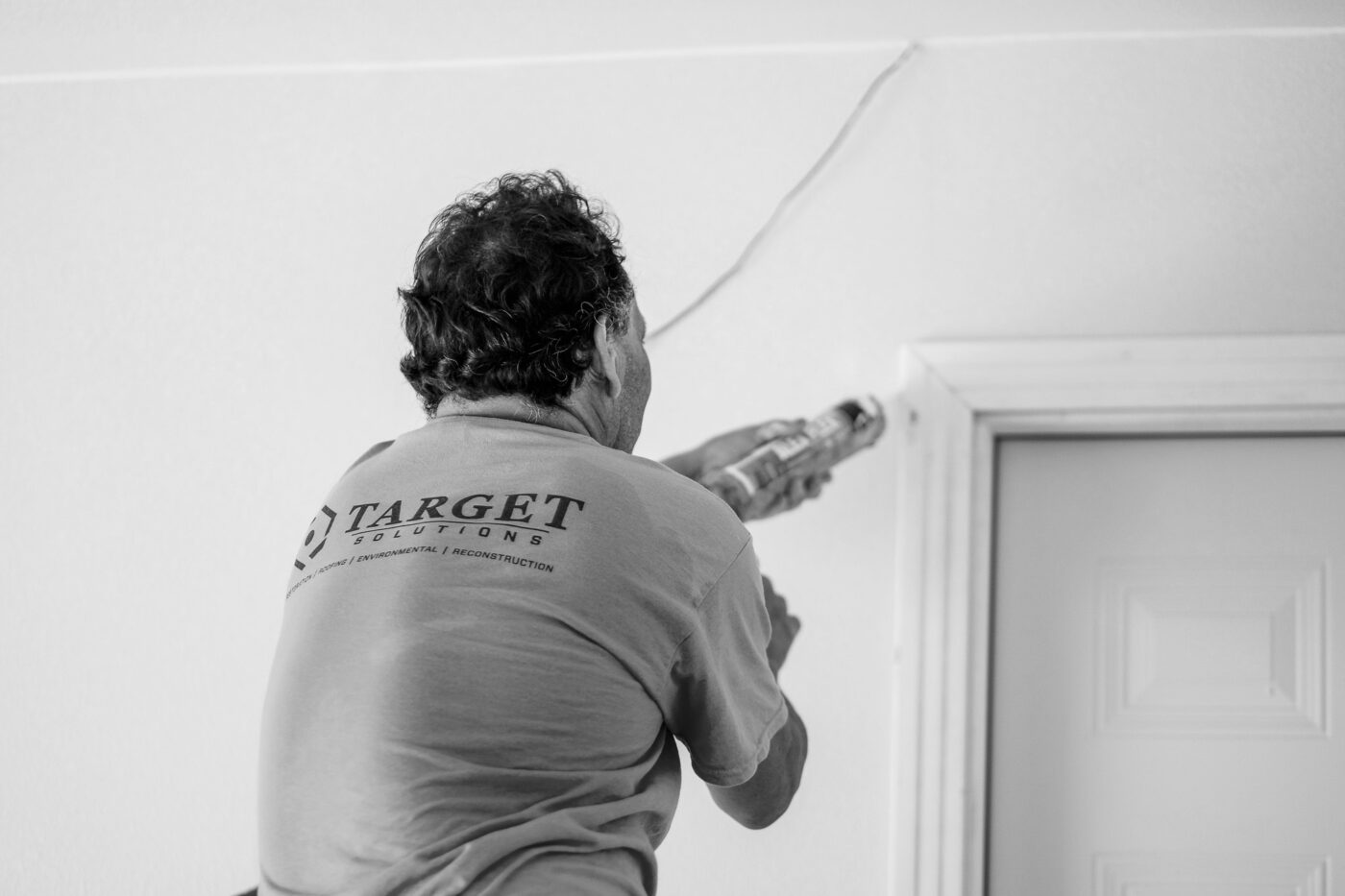 Reconstruction team caulking door frame